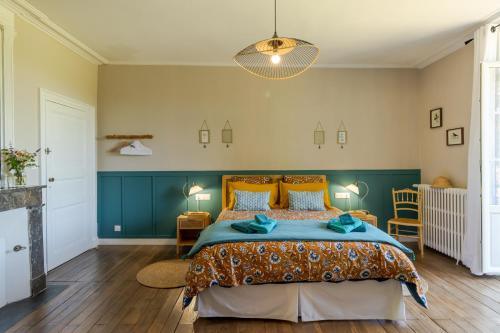 a bedroom with a bed with a blue and orange bedspread at Manoir de La Peytelie in Savignac-les-Églises