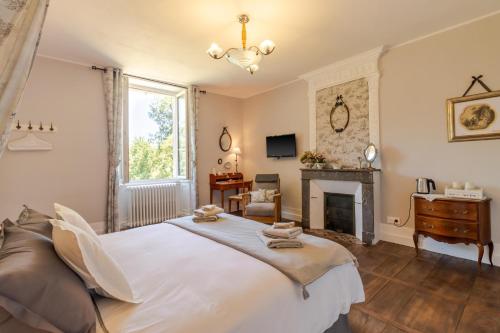 a bedroom with a large bed and a fireplace at Manoir de La Peytelie in Savignac-les-Églises