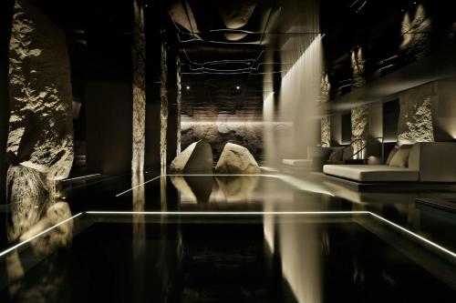 a room with a swimming pool with a couch and a table at HOTEL THE MITSUI KYOTO, a Luxury Collection Hotel & Spa in Kyoto