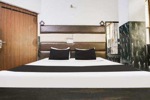 a bedroom with a bed with black and white sheets at Super Hotel O Prayag Hotel in Ludhiana