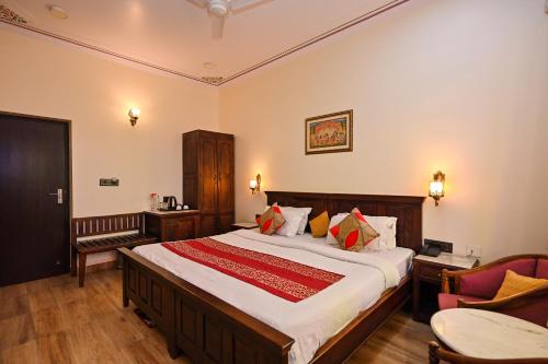 a bedroom with a large bed and a chair at Harnawa Haveli - A Boutique Heritage Stay in Jaipur