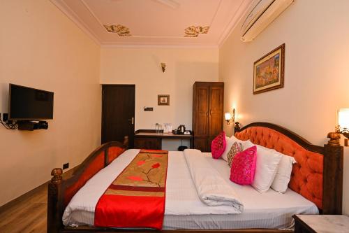 a bedroom with a large bed with pink pillows at Harnawa Haveli - A Boutique Heritage Stay in Jaipur
