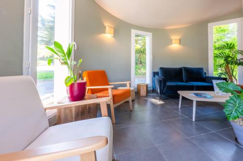 - un salon avec des chaises et un canapé dans l'établissement Résidence Odalys Domaine de l'Emeraude, au Tronchet