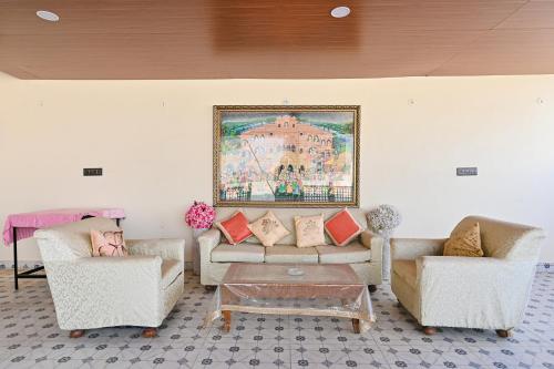a living room with two couches and a painting on the wall at Harnawa Haveli - A Boutique Heritage Stay in Jaipur
