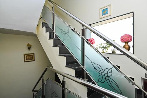 a staircase with glass railings and flowers on the window at Harnawa Haveli - A Boutique Heritage Stay in Jaipur