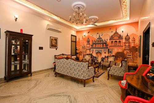 a room with chairs and a painting on the wall at Harnawa Haveli - A Boutique Heritage Stay in Jaipur
