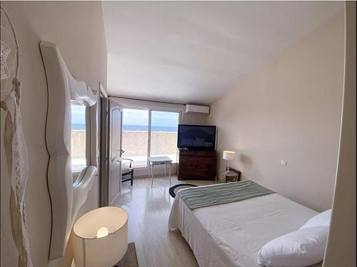 - une chambre avec un lit, une télévision et un balcon dans l'établissement Villa Bollaccia, à Aregno