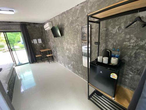 a room with a kitchen with a refrigerator and a table at บ้านสวนวงศ์จินดารักษ์ in Phayao