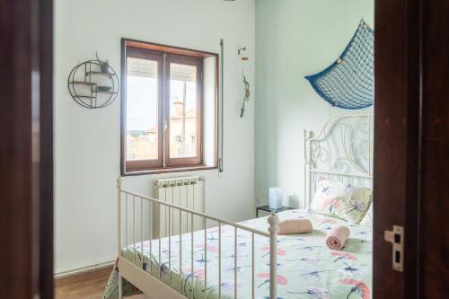 a bedroom with a crib and a window at House with pool and garden in Esmoriz near Porto in Esmoriz