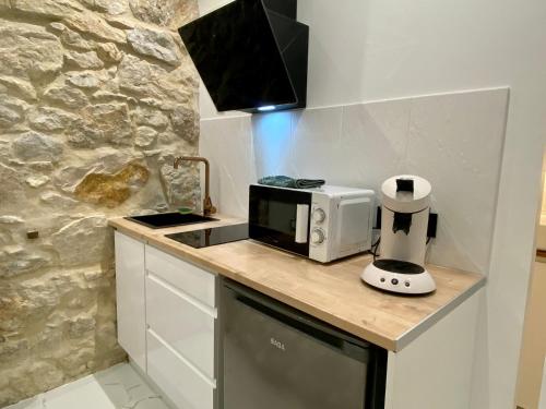 a kitchen with a counter top with a toaster and a microwave at Centre - Climatisation - Calme - Cuisine - Wifi - Tramway in Nice