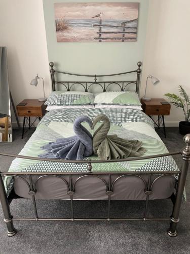 a bed with two towels on top of it at Garden flat in 'Little Chelsea' in Eastbourne