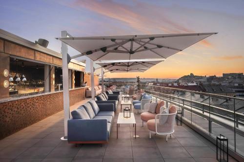 a rooftop bar with couches and tables on a building at W Prague in Prague