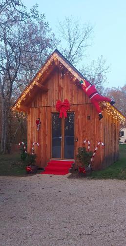 a log cabin with a red bow on it at Gîte Spa & Nature in Saint-Chamassy