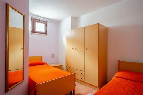 a bedroom with two beds and a mirror at Casa spaziosa per piu' famiglie in Bari Sardo