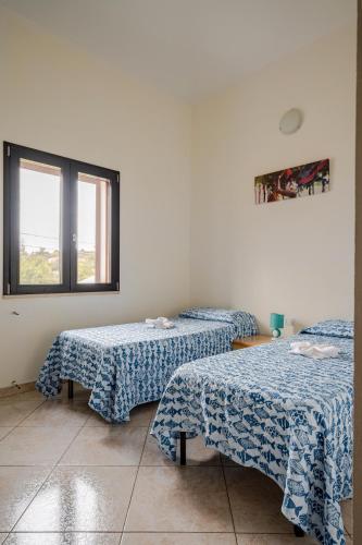 a room with two beds with blue and white sheets at Casa spaziosa per piu' famiglie in Bari Sardo