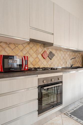 a kitchen with white cabinets and a stove top oven at Casa spaziosa per piu' famiglie in Bari Sardo