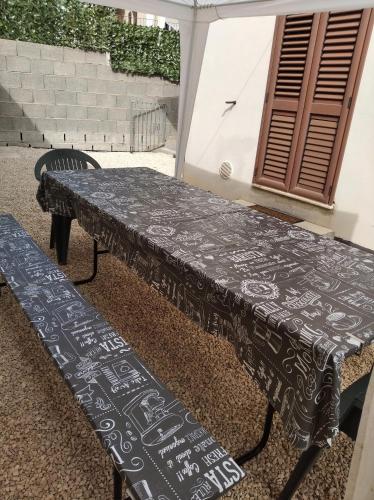 a table with a table cloth on it next to a bench at Casa spaziosa per piu' famiglie in Bari Sardo