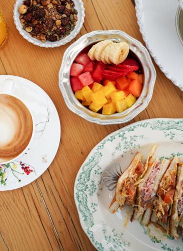 una mesa con platos de comida y una taza de café en Hannah Formentera, en Playa de Migjorn
