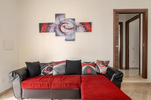 a living room with a red couch and some paintings at Casa spaziosa per piu' famiglie in Bari Sardo