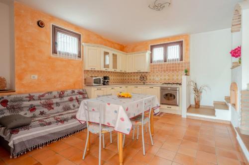 a kitchen with a table and a couch at Casa spaziosa per piu' famiglie in Bari Sardo