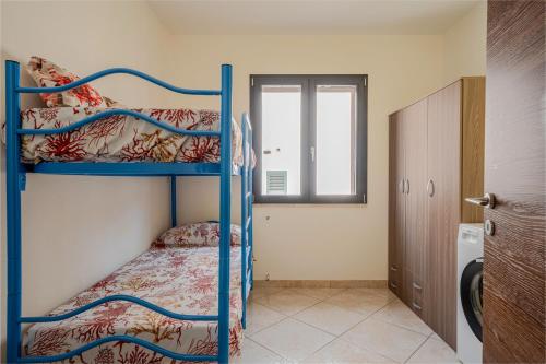 a bedroom with two bunk beds and a window at Casa spaziosa per piu' famiglie in Bari Sardo