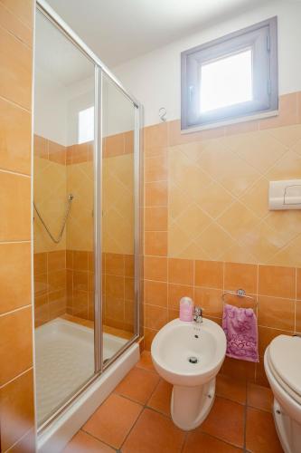 a bathroom with a shower and a toilet and a sink at Casa spaziosa per piu' famiglie in Bari Sardo