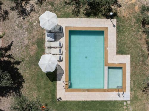 an overhead view of a swimming pool with two umbrellas at Villa Grambella in Sfakaki