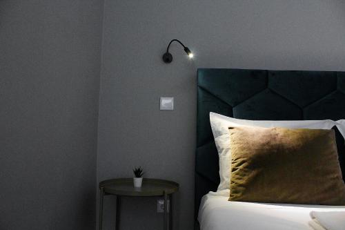 a bedroom with a bed with a black headboard and a side table at Ardósia in Vila Real