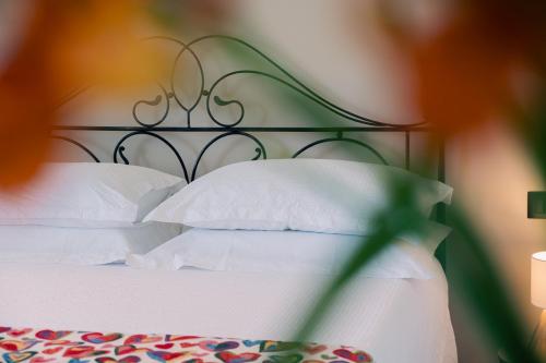 a bed with white pillows and a green head board at Agriturismo Le Marognole in Colà di Lazise