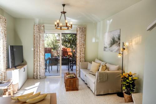 a living room with a couch and a table at Laranca Oneiro Seaside Villa in Perivolia