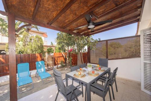 a patio with a table and chairs and a ceiling fan at Laranca Oneiro Seaside Villa in Perivolia