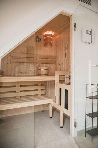 a kitchen with wooden walls and stairs with a glass door at Appartements Brigg & Schoner in Neuharlingersiel