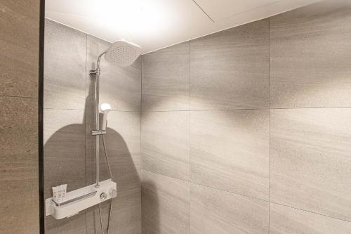 a bathroom with a shower with a shower head at Hotel New Castle Bupyeong in Incheon