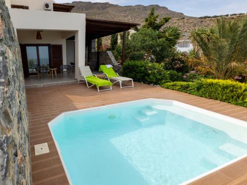 a swimming pool on a patio with a house at Krinakia Villas in Xerokampos