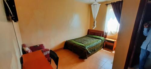 a small room with a bed and a window at Malava-K-Resort in Kakamega