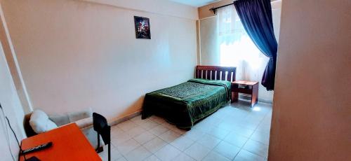 a small bedroom with a bed and a window at Malava-K-Resort in Kakamega
