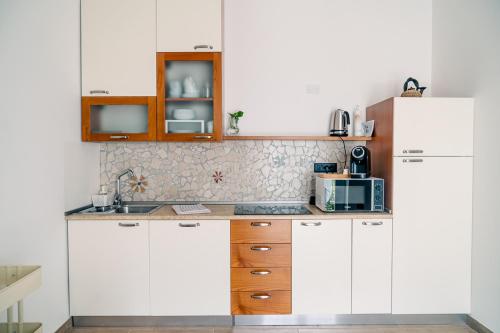 a kitchen with white cabinets and a white refrigerator at Agriturismo Le Marognole in Colà di Lazise