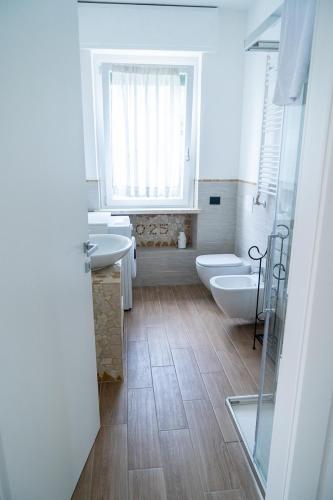 a bathroom with two sinks and a toilet and a window at Agriturismo Le Marognole in Colà di Lazise