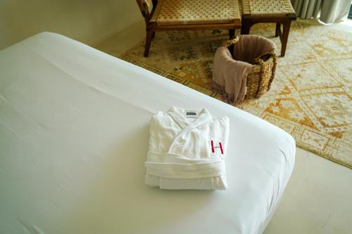 a white bag on a bed with the letter h on it at Hannah Formentera in Playa Migjorn