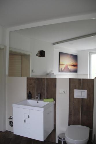 a bathroom with a white sink and a toilet at Apartment Exclusiv in Jena