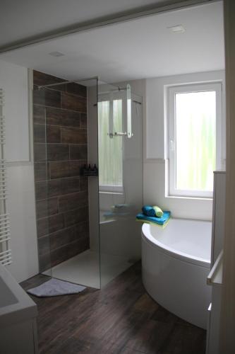 a bathroom with a tub and a glass shower at Apartment Exclusiv in Jena