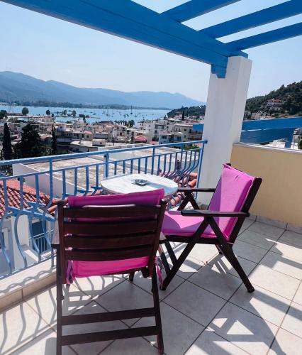 a patio with two chairs and a table on a balcony at KTM Sunny Villas in Poros