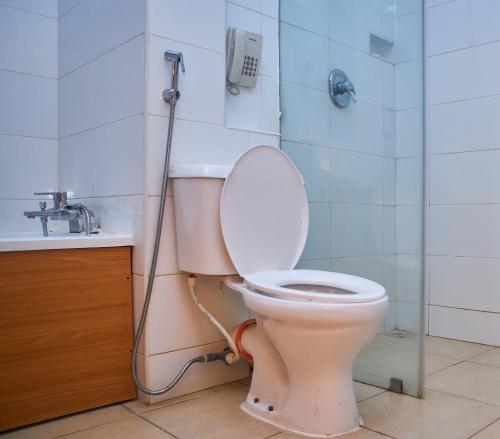 a bathroom with a toilet with a phone on the wall at Royalbirds Hotel & Towers in Akure