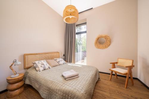 a bedroom with a bed and a chair and a window at Edinburgh loft-style apartments in Jūrmala