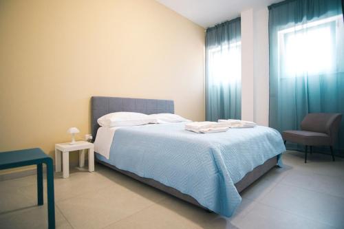 a bedroom with a bed and a chair and a window at Dal Monaco - casa blu in Castellana Grotte
