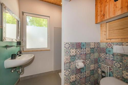 a bathroom with a sink and a toilet and a window at Albatros in Ueckeritz