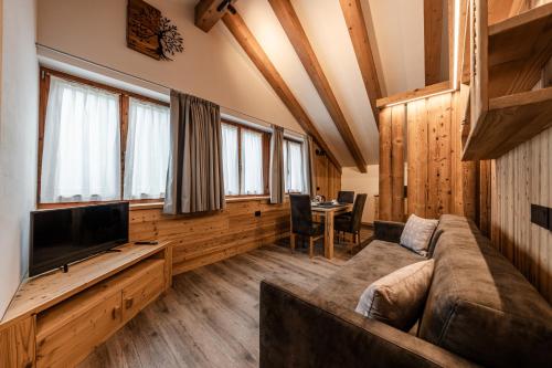 a living room with a couch and a flat screen tv at Villetta Val Di Sole in Commezzadura