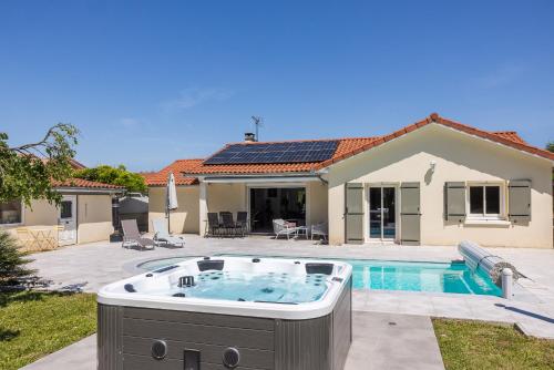 a house with a hot tub in the yard at Villa avec Piscine, Jacuzzi et Sauna Privé dans les Dombes in Ambérieux-en-Dombes