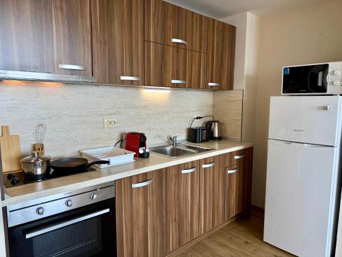 a kitchen with a sink and a white refrigerator at Cosher - Gardenia Palace Apt 11 in Pomorie