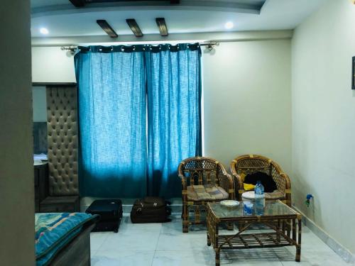 a living room with a table and chairs and a blue curtain at Manzara Hotel & Restaurant in Lower Topa